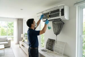 Serwisant wykonuje czyszczenie klimatyzacji w budynku mieszkalnym